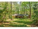 The brick house is surrounded by tall trees and landscaped grass at 2680 Irene Dr, Marietta, GA 30066