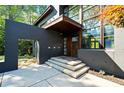 Stunning front entrance featuring a unique portico, grand wood door and modern concrete steps at 265 Tara Trl, Atlanta, GA 30327