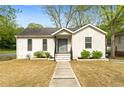 Charming home with a well-manicured lawn and inviting front porch and neutral color palette at 3143 Church St, East Point, GA 30344