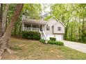 Traditional two-story home with a covered porch, two-car garage, and lush landscaping at 69 Due West Pass, Dallas, GA 30157