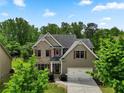 Two-story home featuring brick and siding, a two-car garage, and a well-manicured lawn at 8275 Majors Ridge Way, Cumming, GA 30041