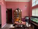 Formal dining room boasting a classic chandelier and pink painted walls at 4206 Shoreside Cir, Snellville, GA 30039
