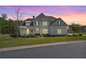 Charming two-story home exterior view at twilight with a well-kept front lawn at 6420 Beacon Station Dr, Cumming, GA 30041