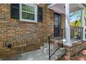 Brick front entrance with black iron railing leading up to a covered porch, offering curb appeal and charm at 6700 Roswell Rd # 19F, Atlanta, GA 30328