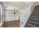 Bright dining room featuring modern hardwood floors, wainscoting, and a decorative chandelier at 1076 Field View Dr, Mcdonough, GA 30253