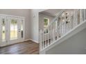 Inviting foyer featuring modern flooring, a decorative glass door, and a white staircase at 1076 Field View Dr, Mcdonough, GA 30253