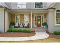 Inviting front porch with stone accents and seating area at 1315 Woodland Trce, Cumming, GA 30041