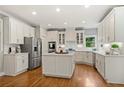 Updated kitchen with white cabinetry, stainless appliances, center island, and hardwood floors at 1315 Woodland Trce, Cumming, GA 30041