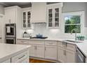 Gorgeous kitchen with white subway tile backsplash, white cabinets, and stainless steel appliances at 1315 Woodland Trce, Cumming, GA 30041