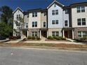 Townhome exteriors showcasing brick and wood siding, complemented by lush landscaping and tree-lined street at 1608 Falcon Crest Way # 58, Decatur, GA 30032