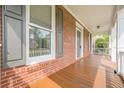 Side view of the charming front porch featuring sturdy columns and stained wood flooring adding to the curb appeal at 1611 Threepine Pl, Lilburn, GA 30047