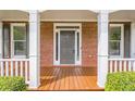 Inviting front porch with sturdy columns, wood flooring, and charming curb appeal, perfect for relaxing outdoors at 1611 Threepine Pl, Lilburn, GA 30047