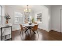 Charming dining area featuring hardwood floors, white wainscoting, and a stylish modern light fixture at 1612 Alder Se Ct, Atlanta, GA 30317