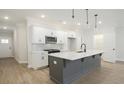 A kitchen featuring an island with light countertops, white cabinets, and hardwood floors at 170 Bluffington Way, Marietta, GA 30066