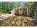 Charming two-story brick home with a columned front porch, mature trees, and manicured landscaping at 4128 Mayflower Sw Ct, Lilburn, GA 30047