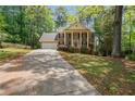 Two-story brick home with manicured lawn, columns, mature trees, and long driveway at 4128 Mayflower Sw Ct, Lilburn, GA 30047