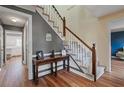 Hallway with hardwood floors leads to the staircase with white balusters and carpeted treads at 4128 Mayflower Sw Ct, Lilburn, GA 30047