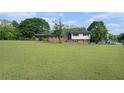 Sprawling lawn complements this home with a brick front, black shutters, and convenient carport at 1548 Highway 81 W, Mcdonough, GA 30253