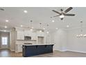 Bright, modern kitchen with stainless appliances, white cabinets, a dark island, and sleek pendant lighting at 158 Bluffington Way, Marietta, GA 30066