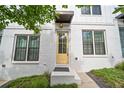 Up close, charming townhome featuring white brick and a bright yellow front door with an awning at 1227 Cushenberry Ln, Atlanta, GA 30318