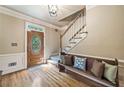 Inviting foyer featuring hardwood floors, staircase, decorative bench, and stained glass front door at 2885 Arborwoods Dr, Alpharetta, GA 30022