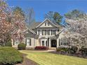 Attractive two-story home with well-kept lawn, complemented by blooming trees adding charm and curb appeal at 330 Plantation Way, Roswell, GA 30075