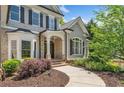 Inviting front entrance features brick accents, a covered porch, and manicured landscaping creating a warm welcome at 330 Plantation Way, Roswell, GA 30075