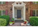 Inviting front entry featuring a decorative door, brick walkway, and manicured greenery at 3585 Legacy Trce, Alpharetta, GA 30022