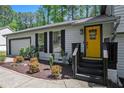 Close-up of a home's entrance, showing the bright yellow door, and landscaped front yard at 2022 Ramblewood Ne Ct, Marietta, GA 30062