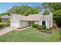 Charming home featuring a well-manicured lawn, complemented by a 2-car garage and mature trees in the background at 1970 Glen Eves Dr, Roswell, GA 30076