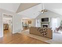 Bright and airy living room featuring a cozy fireplace, a vaulted ceiling with a fan, and seamless hardwood flooring at 1970 Glen Eves Dr, Roswell, GA 30076