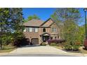 Charming two-story brick home with a manicured front yard and a two-car garage at 3097 Trinity Grove Dr, Dacula, GA 30019