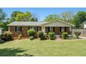 Charming brick home with a well-maintained lawn and inviting curb appeal, black shutters, and a cozy front porch at 1085 Azalea Ne Cir, Marietta, GA 30062