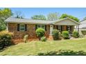 Inviting brick home with lush lawn, manicured bushes, and a classic design at 1085 Azalea Ne Cir, Marietta, GA 30062