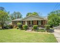 Quaint brick home featuring a lush green lawn, mature shrubbery, and a welcoming front entrance at 1085 Azalea Ne Cir, Marietta, GA 30062