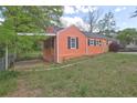 Side view of home with carport, fenced yard and well-maintained lawn at 5164 Phillips Dr, Forest Park, GA 30297