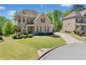 Charming brick home featuring lush landscaping and a curved driveway, perfect for curb appeal at 6090 Pennant Ln, Suwanee, GA 30024