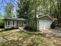 Charming home featuring a well-maintained lawn and an attached garage in a serene, wooded setting at 921 Hemingway Rd, Stone Mountain, GA 30088