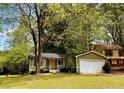 Picturesque home nestled amongst lush trees, showcasing a well-kept lawn and an attached two-car garage at 921 Hemingway Rd, Stone Mountain, GA 30088