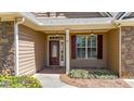 Inviting front porch with a mahogany-stained front door, craftsman-style trim, and professional landscaping at 28 Summer Nw Pl, Cartersville, GA 30121