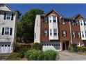 Two-story red brick townhome with a two-car garage, complemented by green shrubs at 5229 Pinnacle Pointe Ct, Norcross, GA 30071