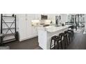 Panorama of kitchen with island and seating, white cabinets, and stainless steel appliances at 1050 Stacks Ave # 1507, Atlanta, GA 30315
