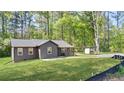 Quaint single-story house on a green lawn with covered carport, surrounded by mature trees at 3917 Dallas Acworth Nw Hwy, Acworth, GA 30101