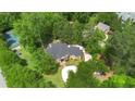 An aerial view of a brick home nestled in a lush green landscape, showcasing a well-maintained tennis court nearby at 3 Woodlawn Ne Dr, Marietta, GA 30067