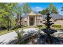 Elegant brick home featuring a grand entrance with columns and a fountain, surrounded by manicured landscaping at 3 Woodlawn Ne Dr, Marietta, GA 30067
