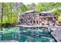 Gorgeous outdoor pool area, perfect for entertaining in a private backyard with lush trees at 7635 Blandford Pl, Atlanta, GA 30350