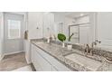 Beautiful bathroom featuring dual sinks, granite countertops, white cabinets, and a glass-enclosed shower at 407 Newland Way, Acworth, GA 30102