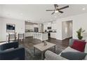 Bright, open-concept living space featuring hardwood floors, white walls, modern lighting and adjoined kitchen at 407 Newland Way, Acworth, GA 30102