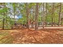 Scenic view of a brown two-story home surrounded by mature trees and a sprawling yard at 5350 Rockbridge Rd, Stone Mountain, GA 30088