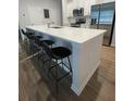 Modern kitchen boasts a large island with seating, stainless steel appliances, and sleek white cabinetry at 251 Turner Ln, Woodstock, GA 30188